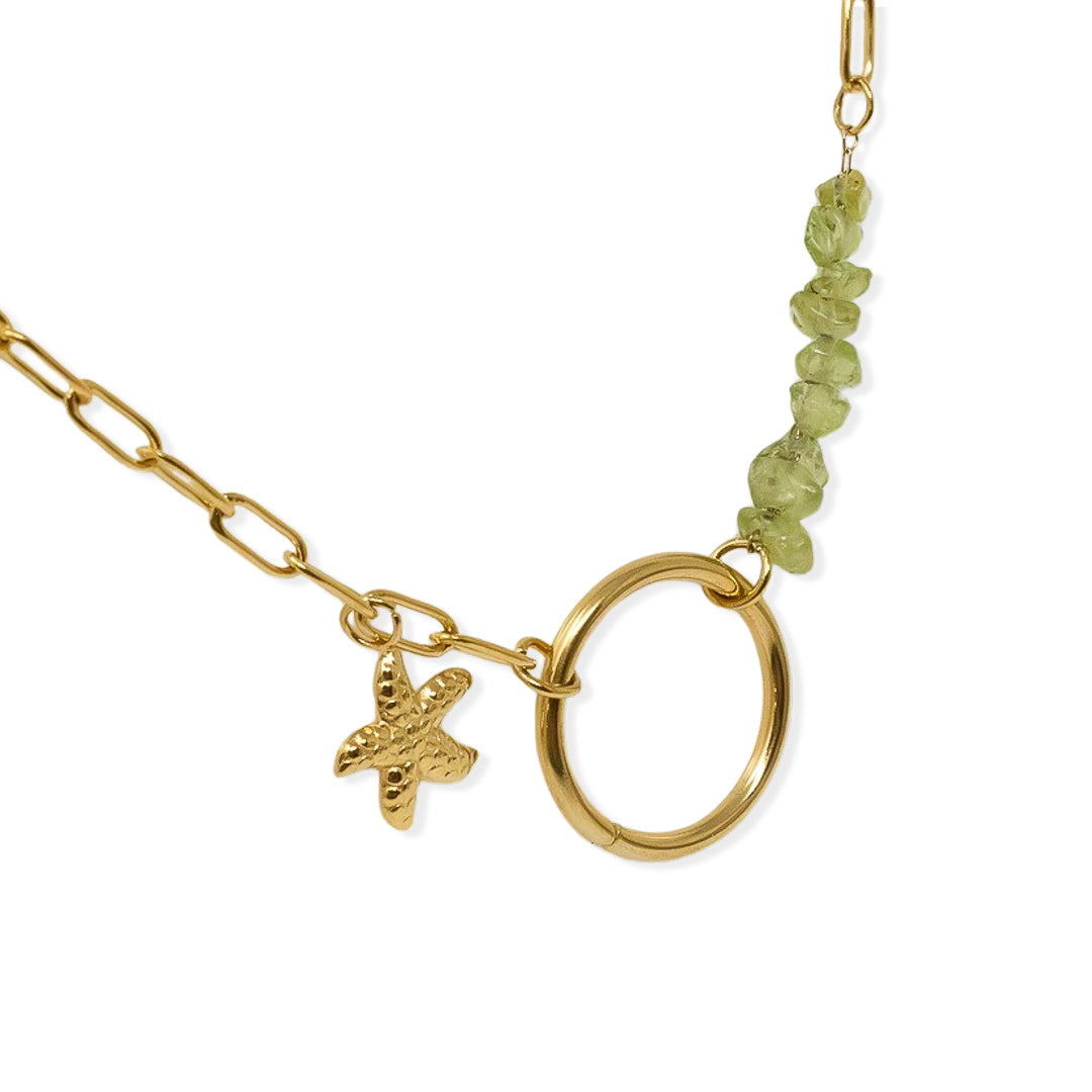 Colgante de acero bañado en oro con círculo de olivinas y estrella de mar, detalle